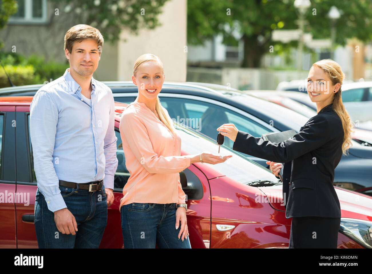 Dealer Giving Car Key To Couple Stock Photo - Alamy