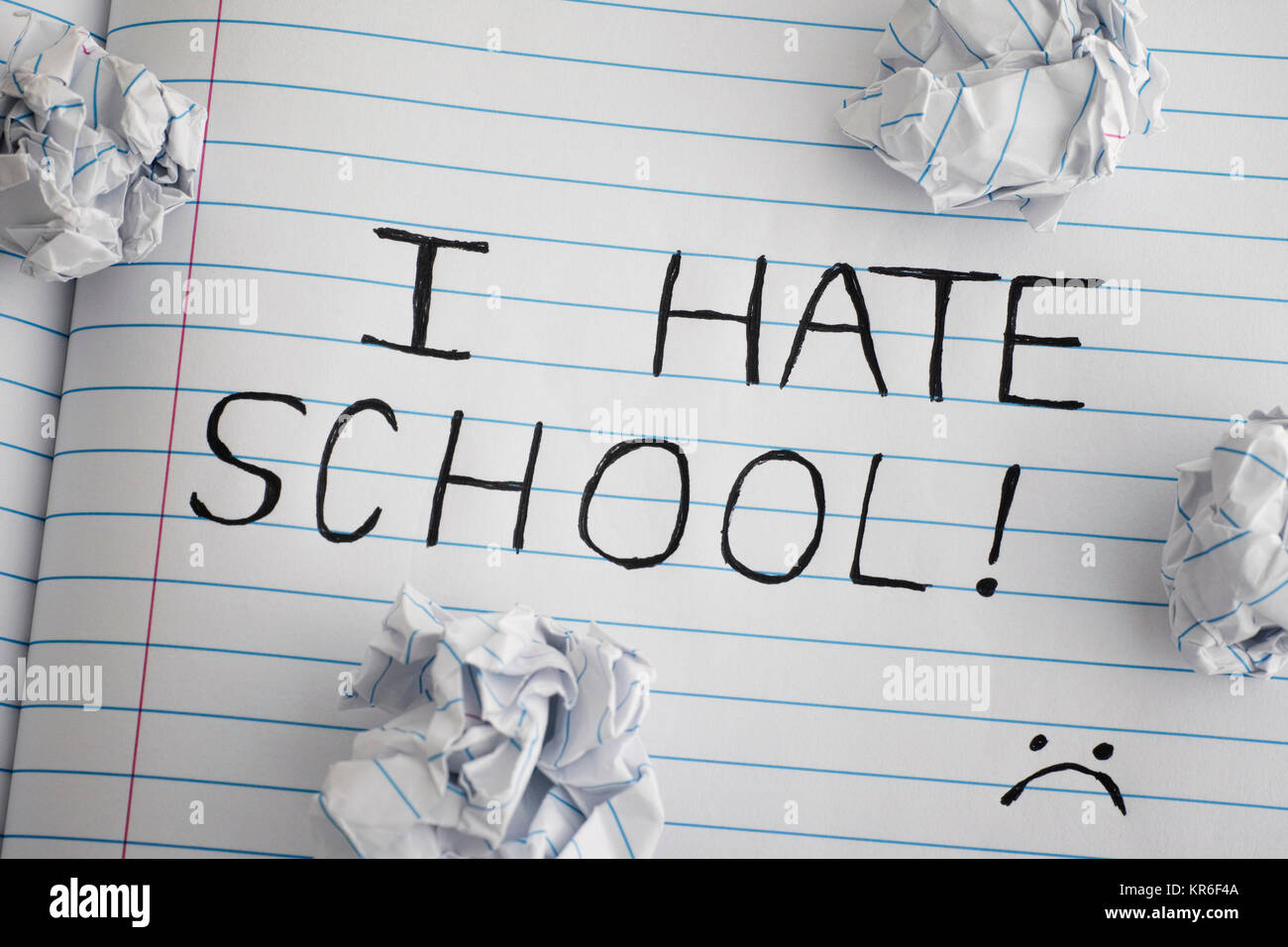 I Hate School. Phrase I Hate School on notebook sheet with some crumpled paper balls on it. Close up. Stock Photo