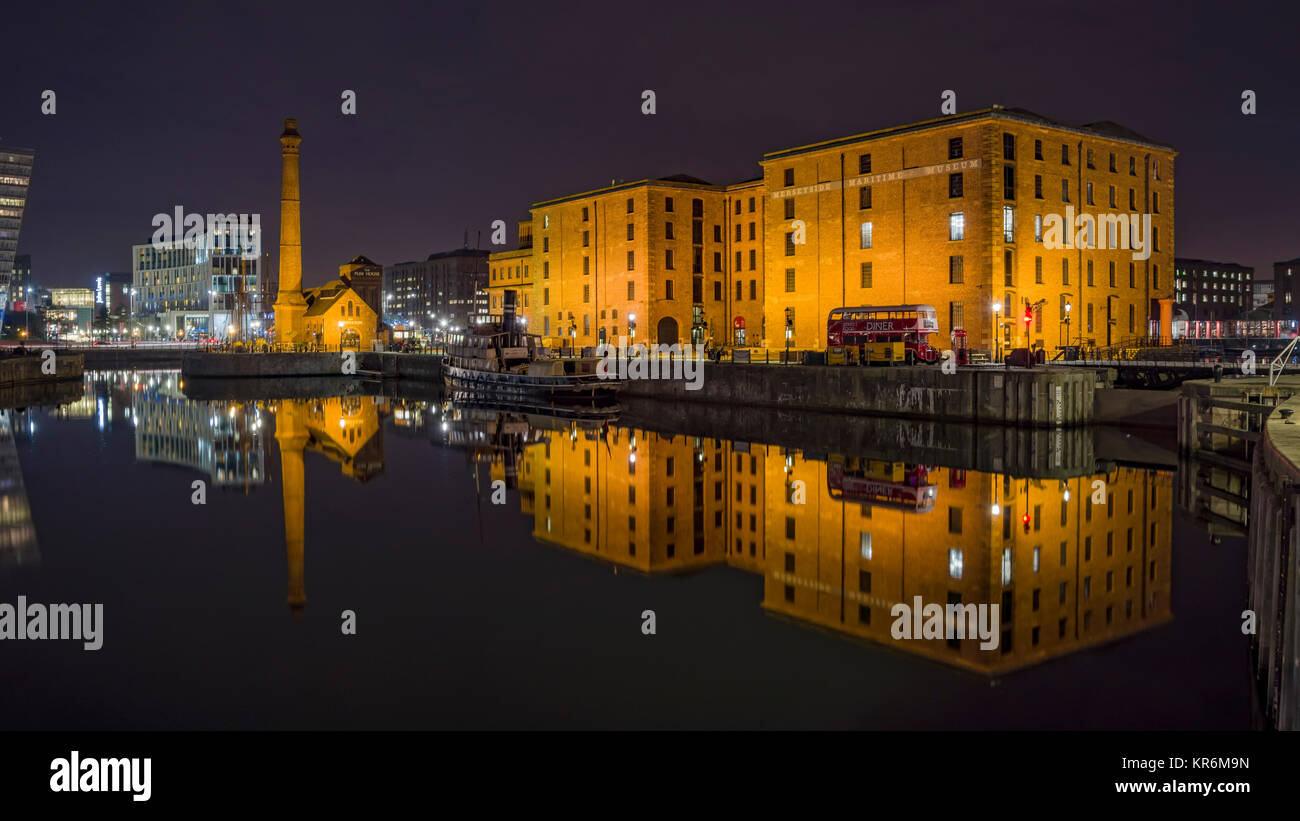 View at Night across the Canning Dock to Hartley Quay showing the Liverpool Maritime Museum Building and the Pump House reflected in the water Stock Photo