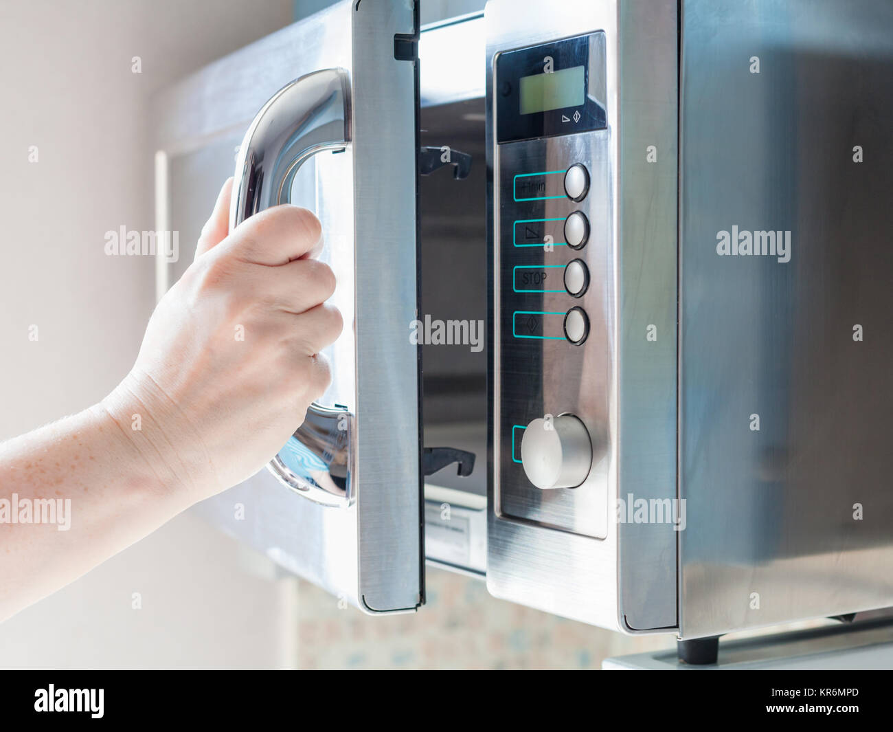 hand opens microwave oven for cooking food Stock Photo Alamy