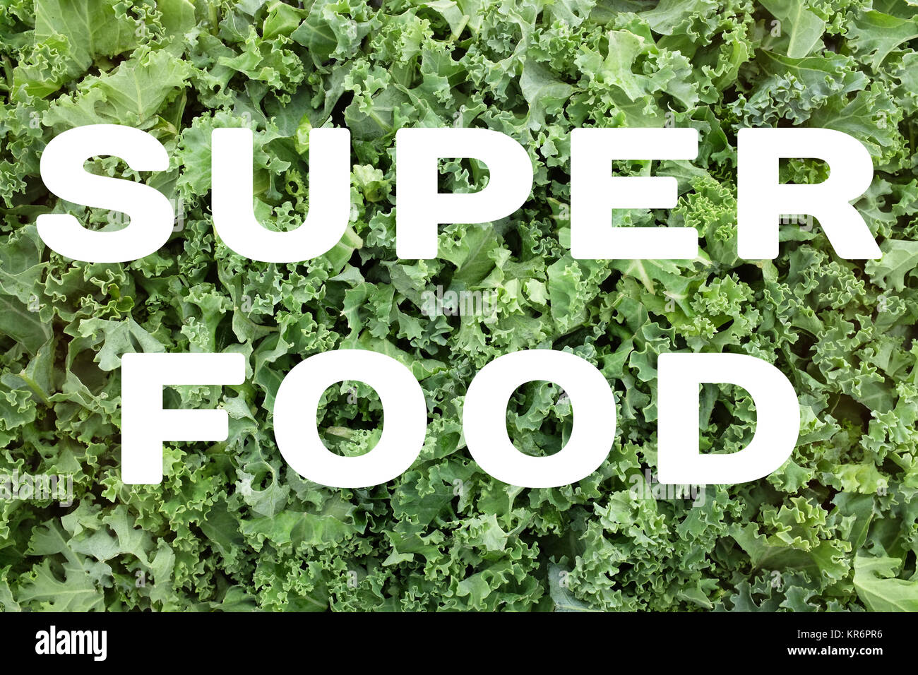 SUPERFOOD text over shredded kale leaves background Stock Photo