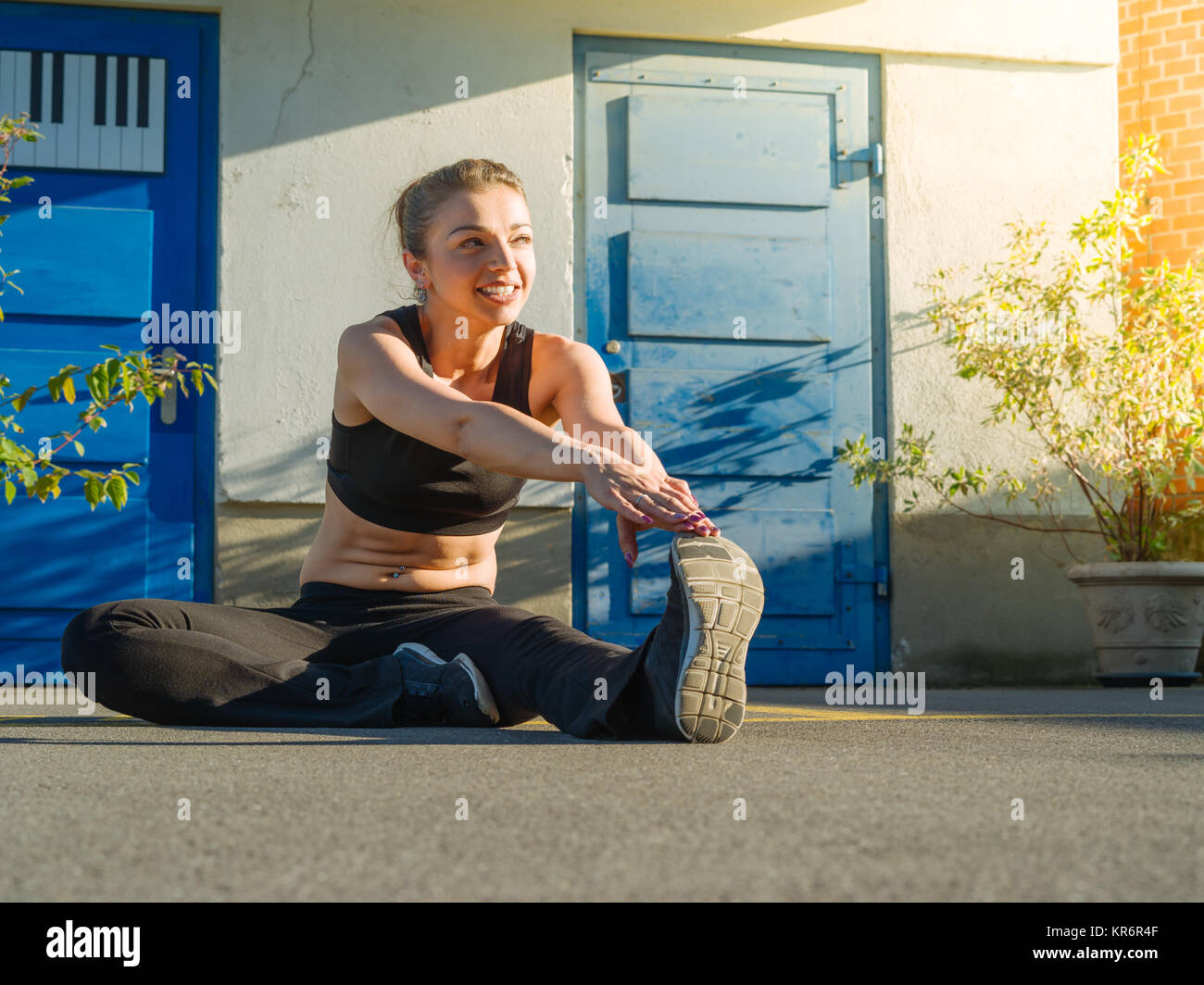 Young woman stretching outdoors Stock Photo