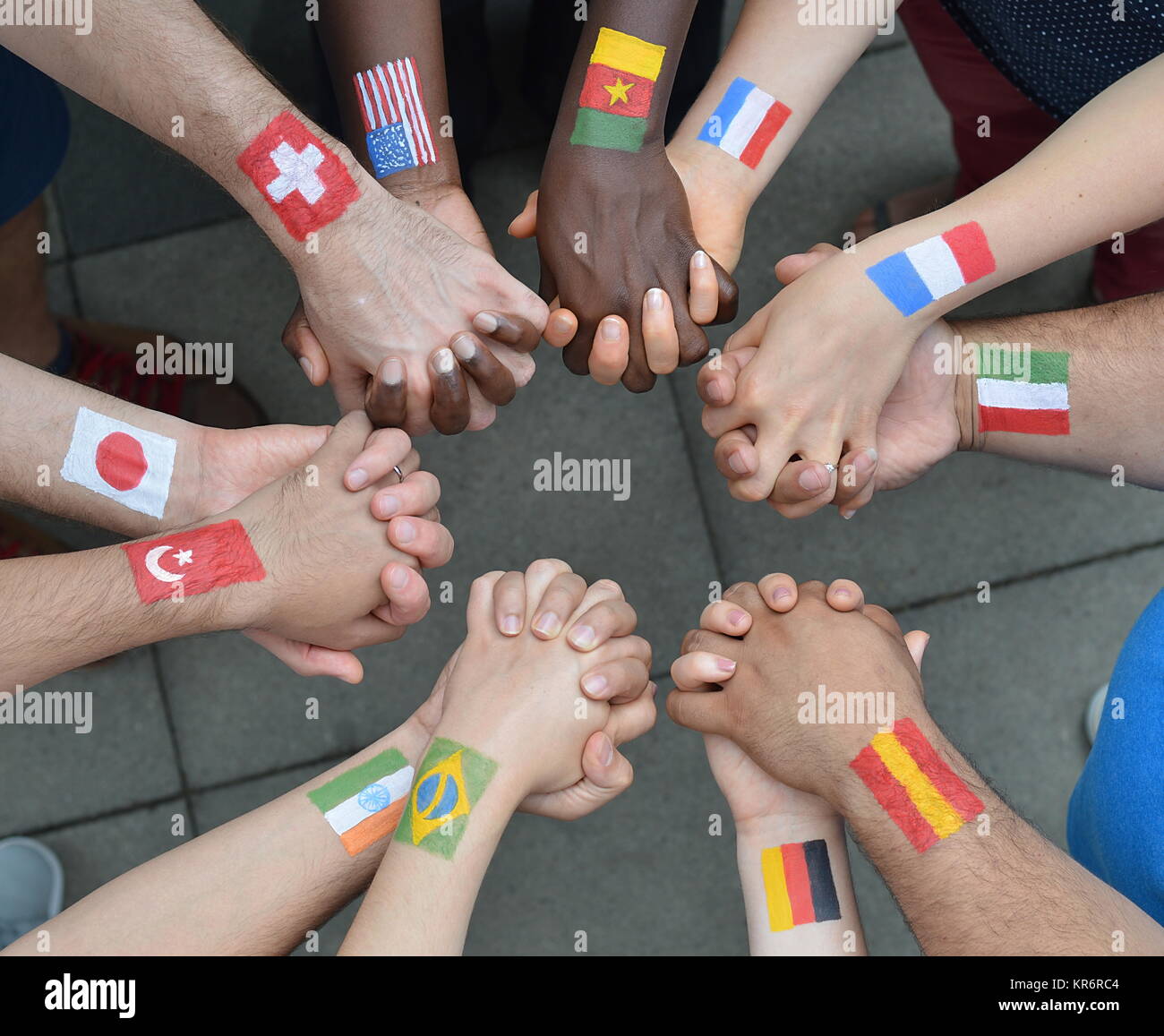 International brothers and sisters standing in a circle together and holding hands Stock Photo