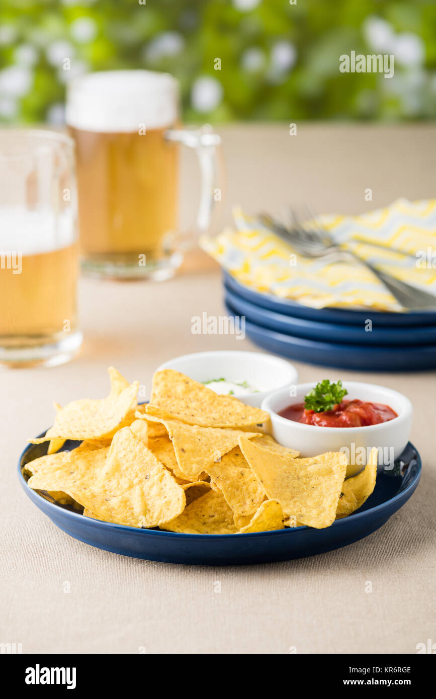 Nachos with salsa and sour cream dips with beers Stock Photo Alamy