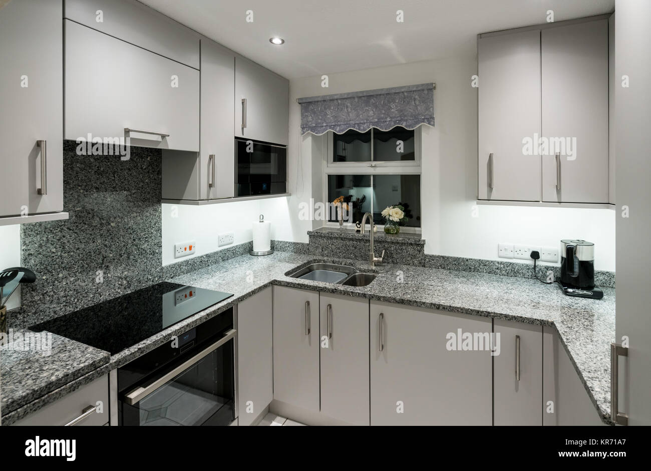 Small modern kitchen in apartment with granite worktop Stock Photo - Alamy