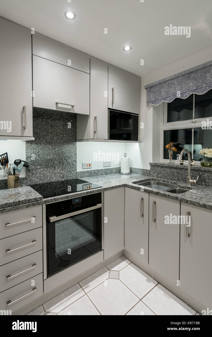 Small modern kitchen in apartment with granite worktop Stock Photo