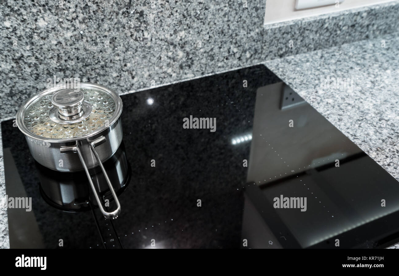 Stainless steel pan on modern induction hob or cooktop Stock Photo