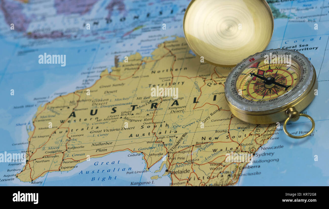 Compass on a close up map pointing at Australia and planning a travel