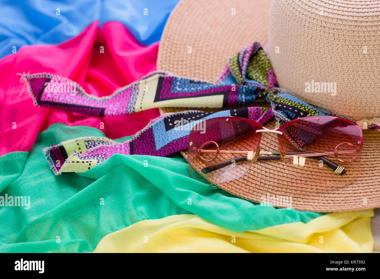 A straw hat and sunglasses on a colored fabric background. Tourism ...