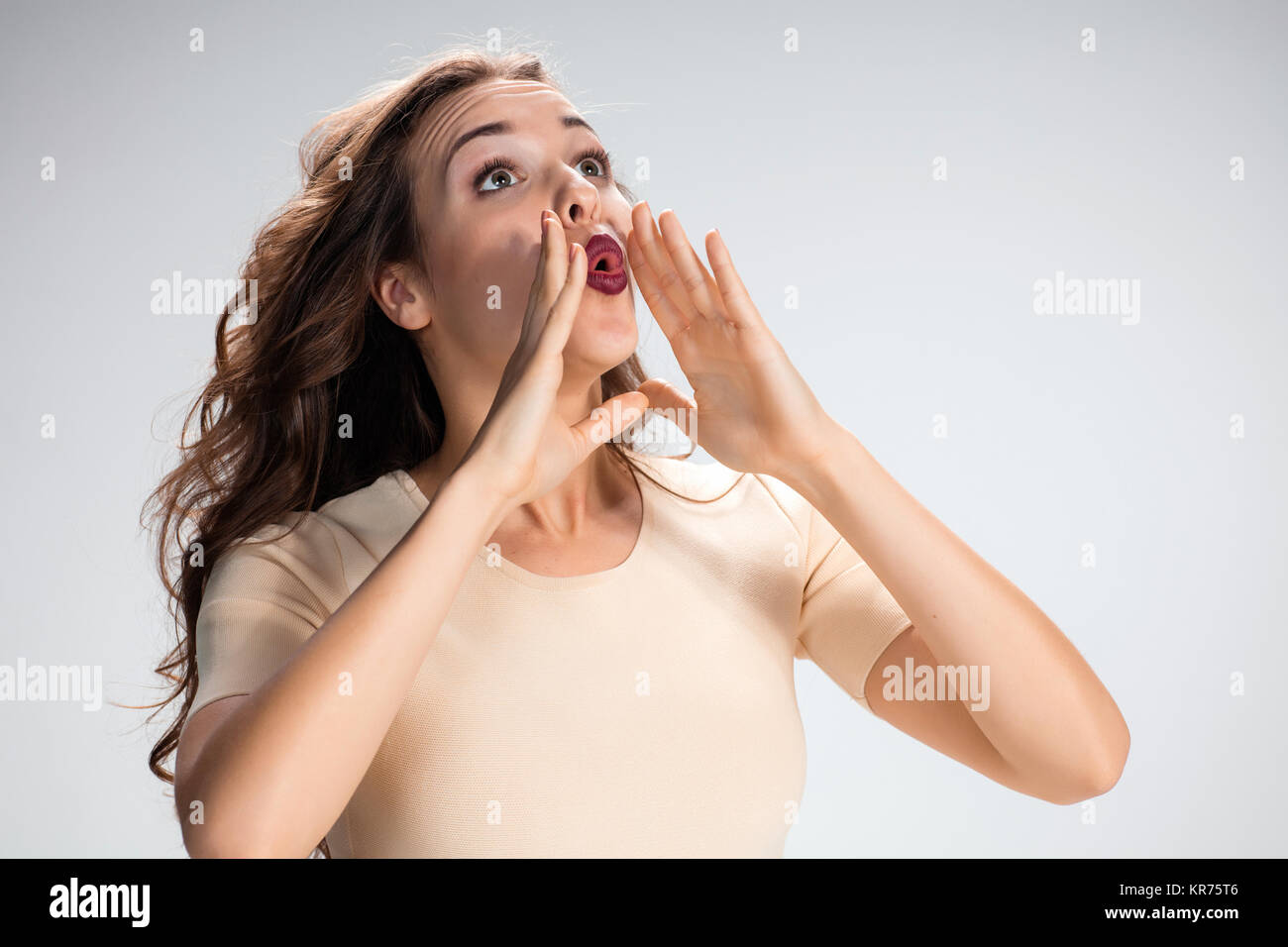 The calling girl or woman on gray background Stock Photo