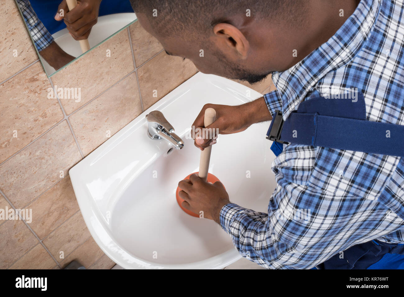 Plumber's Hand Using Plunger In Bathroom Sink Stock Photo Alamy