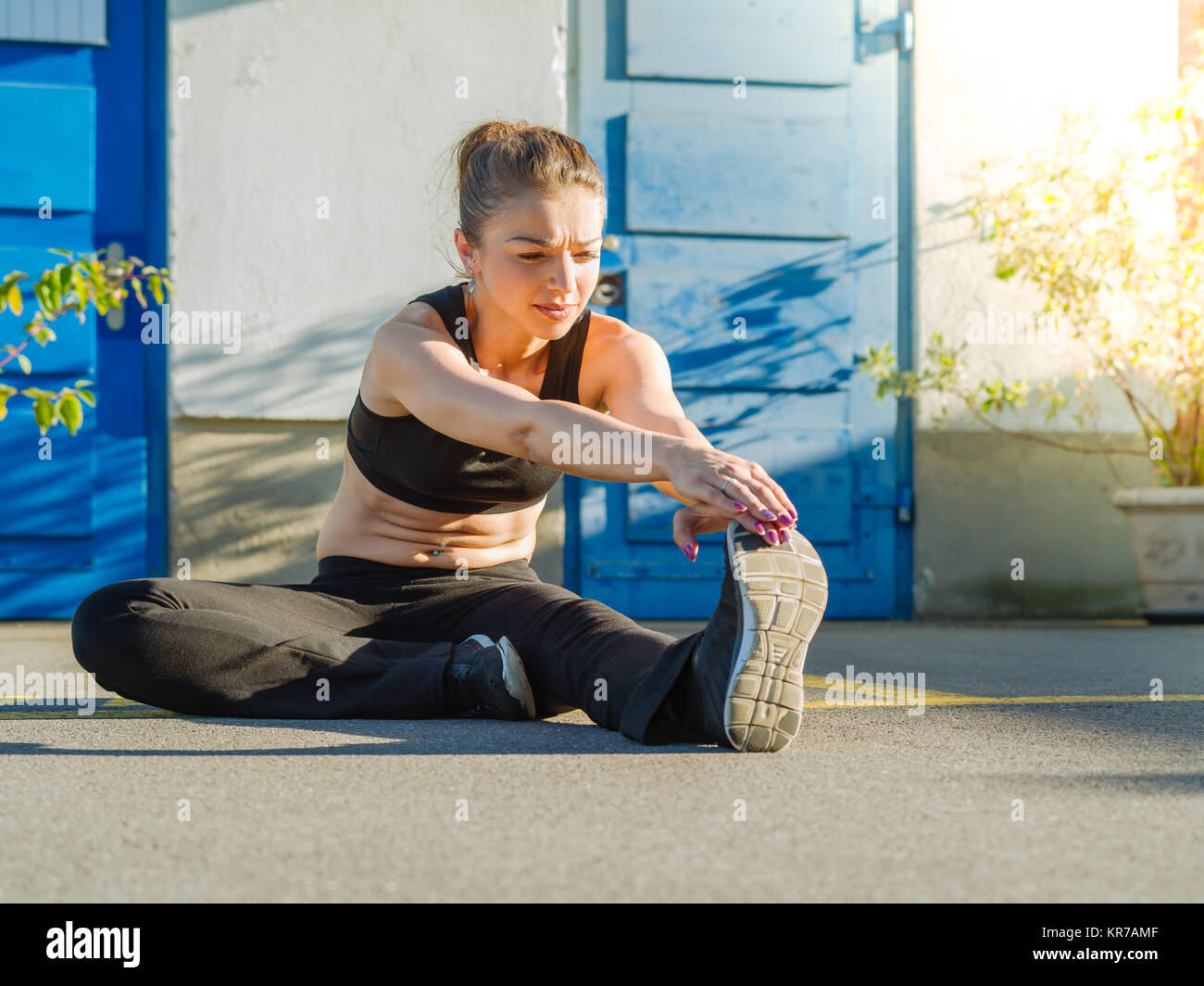 Young woman stretching her legs outdoors Stock Photo