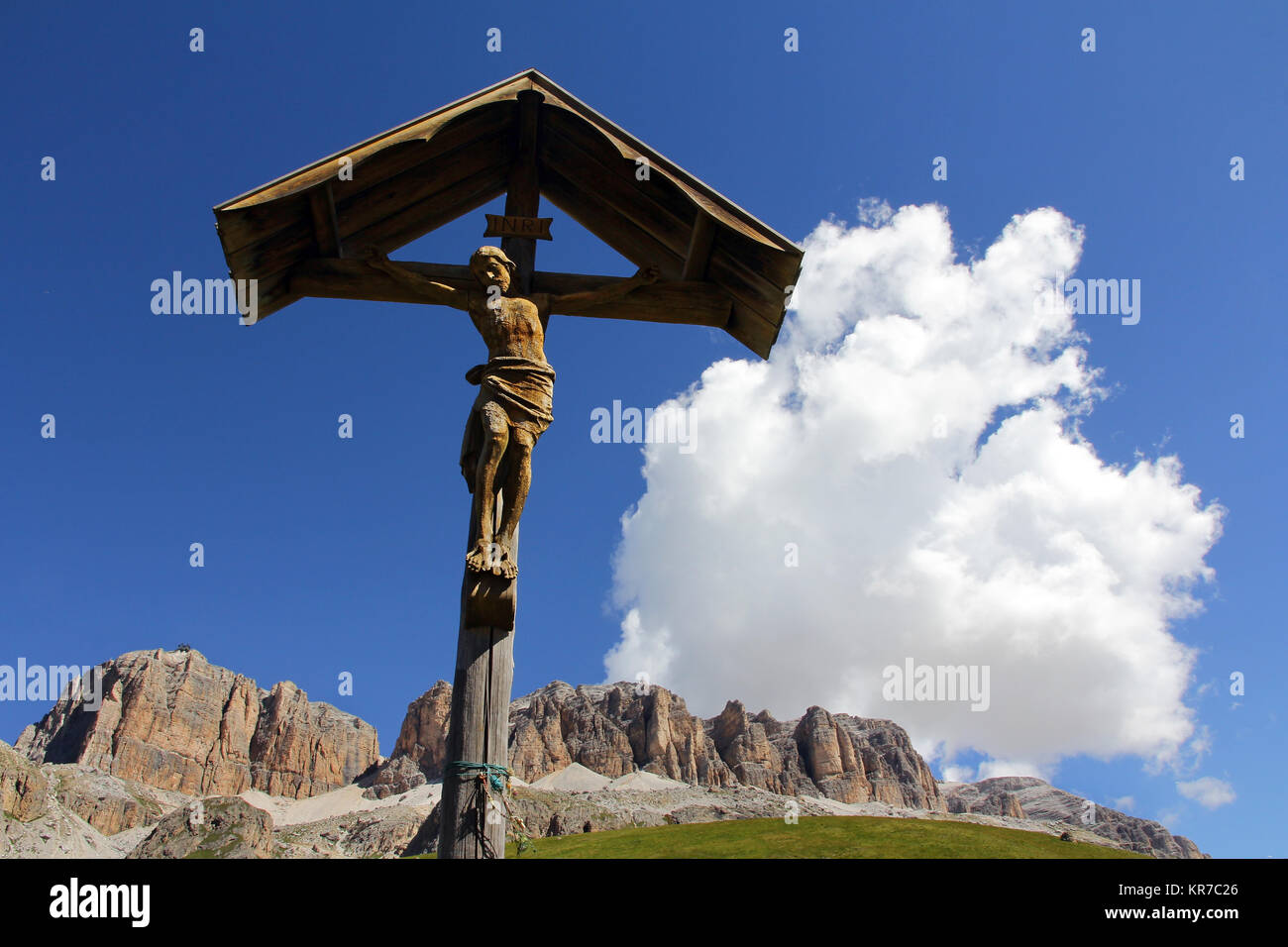 a christian cross made of wood in the mountains. wooden cross with jesus in the dolomites in italy Stock Photo