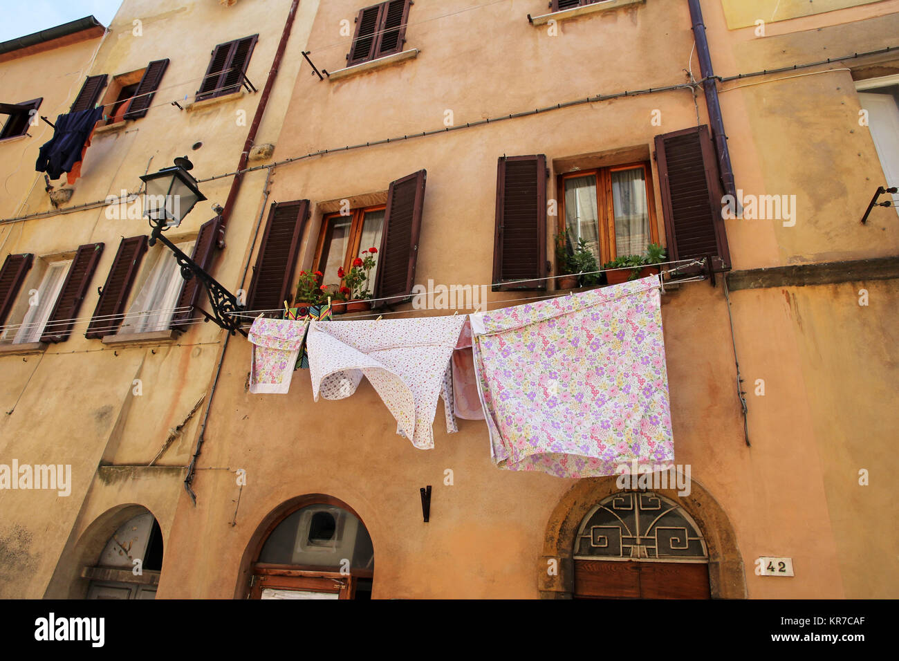 a clothesline with laundry of an old house in italy. freshly washed clothes in front of a house Stock Photo