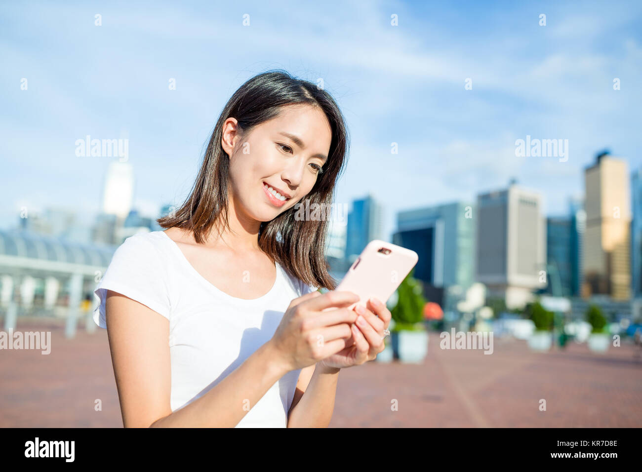 Woman using mobile phone in Hong Kong city Stock Photo - Alamy