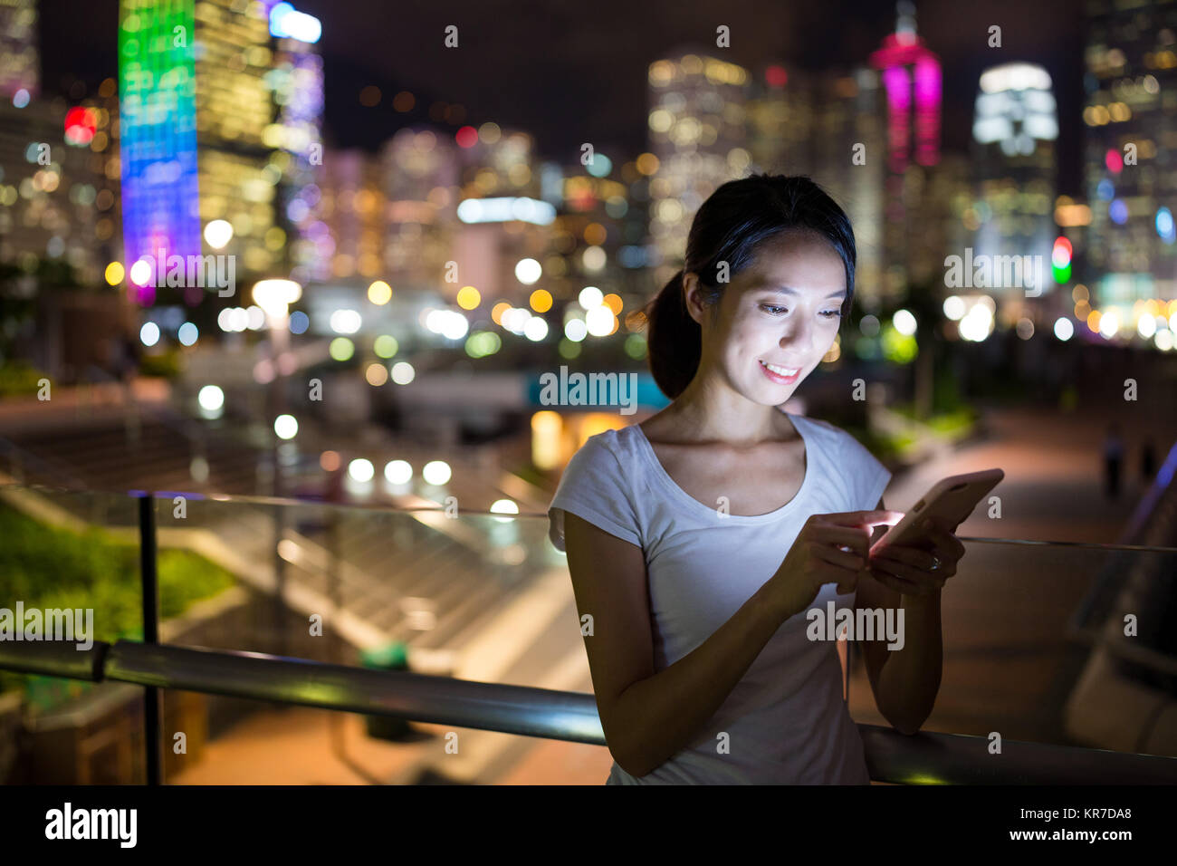 Woman using cellphone at night in Hong Kong Stock Photo - Alamy