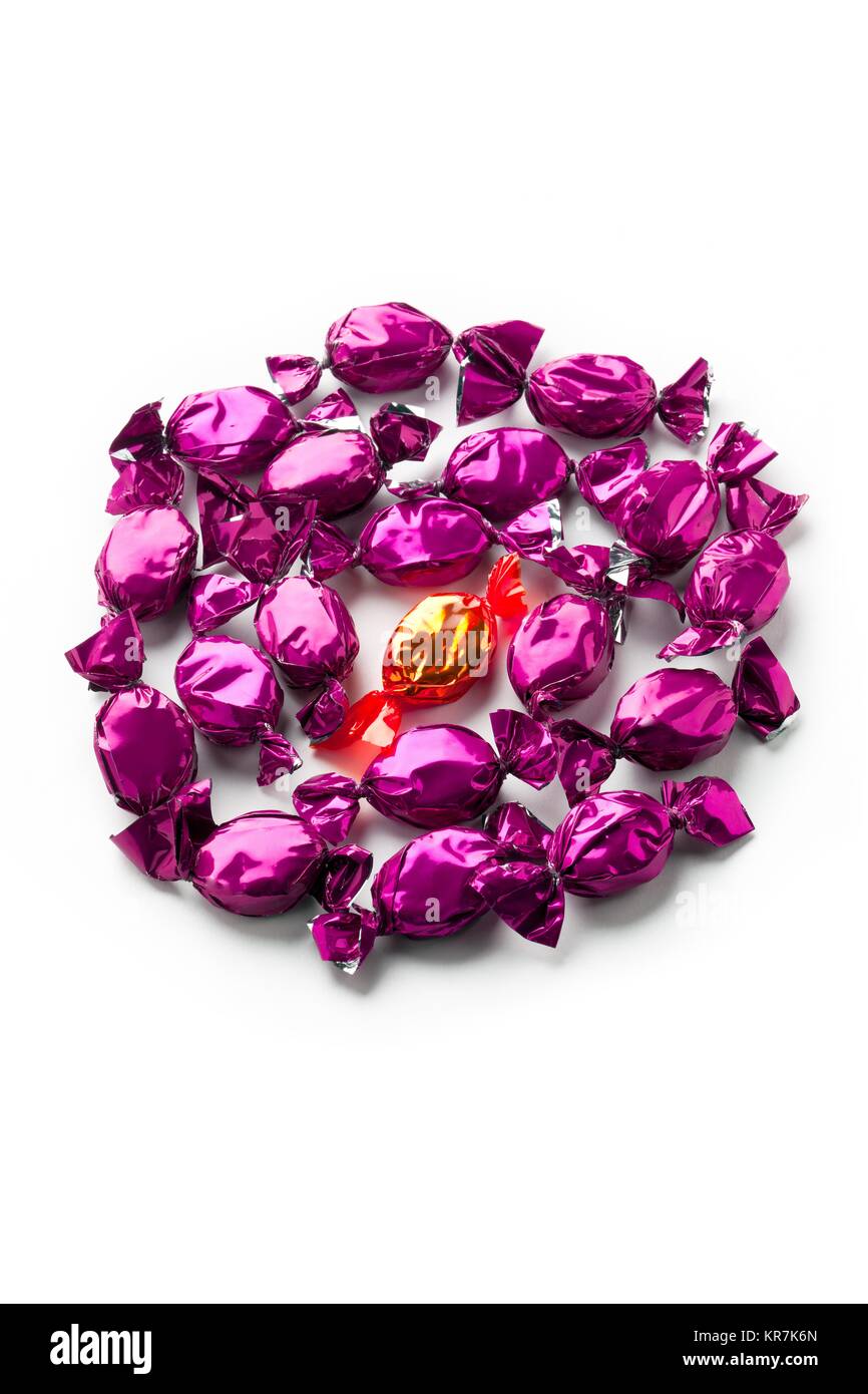 top view of golden hard candy surrounded by purple shiny hard candies