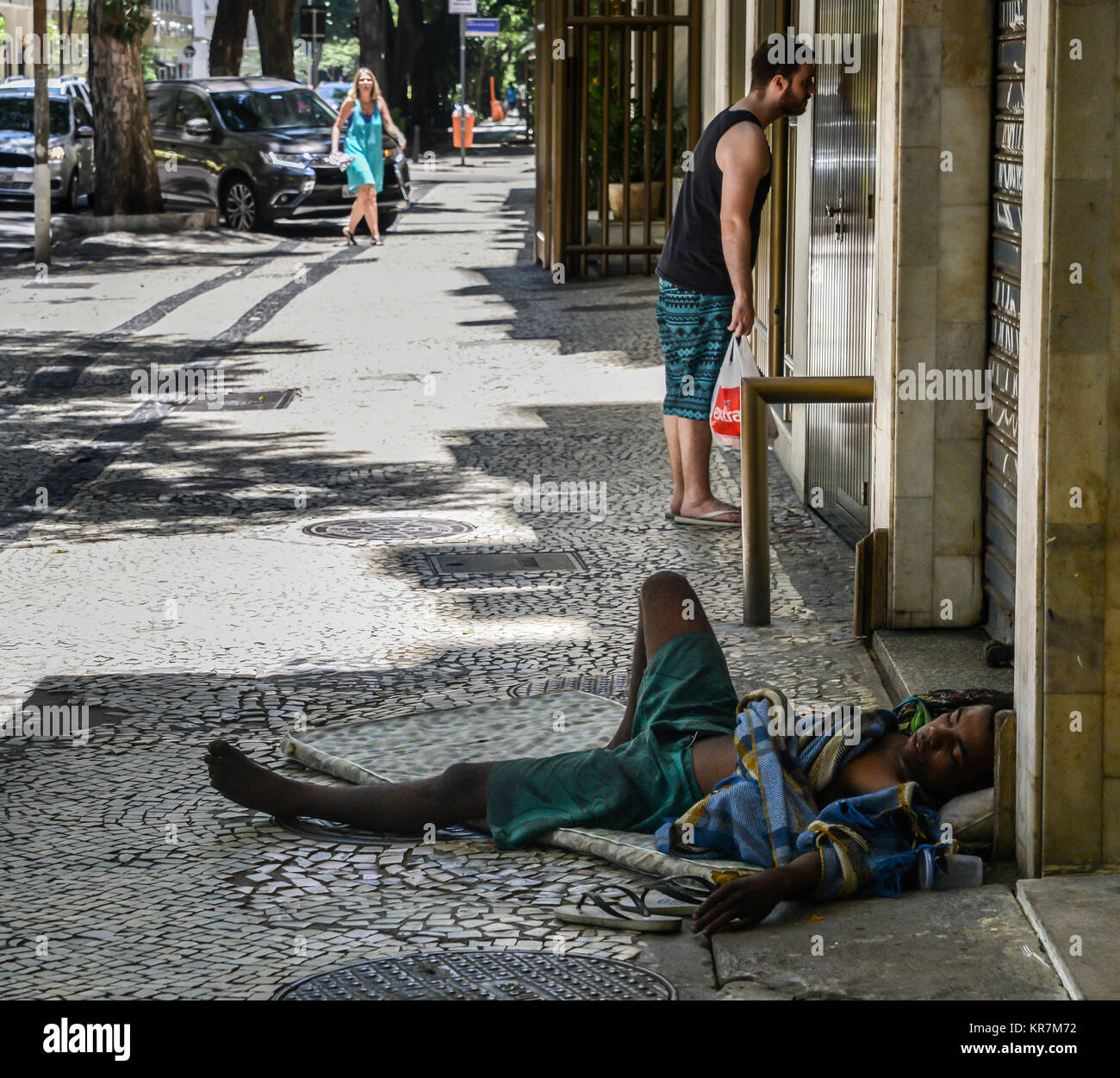 Brazilian mixed race homeless man sleeps rough on the street. Rio de