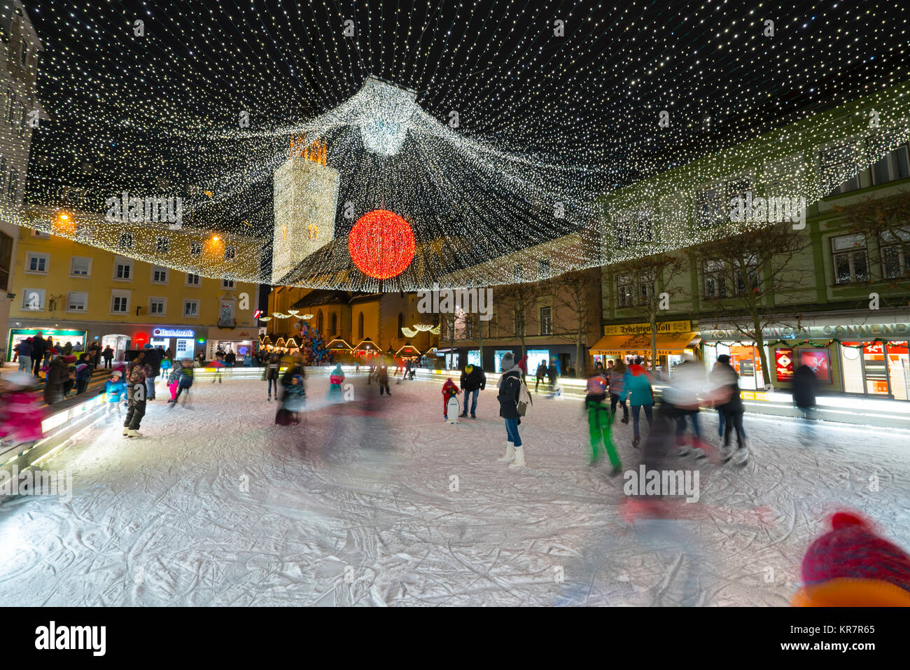 people are skating in the ice rink in a square in the historic center of Villach, Austria Stock Photo