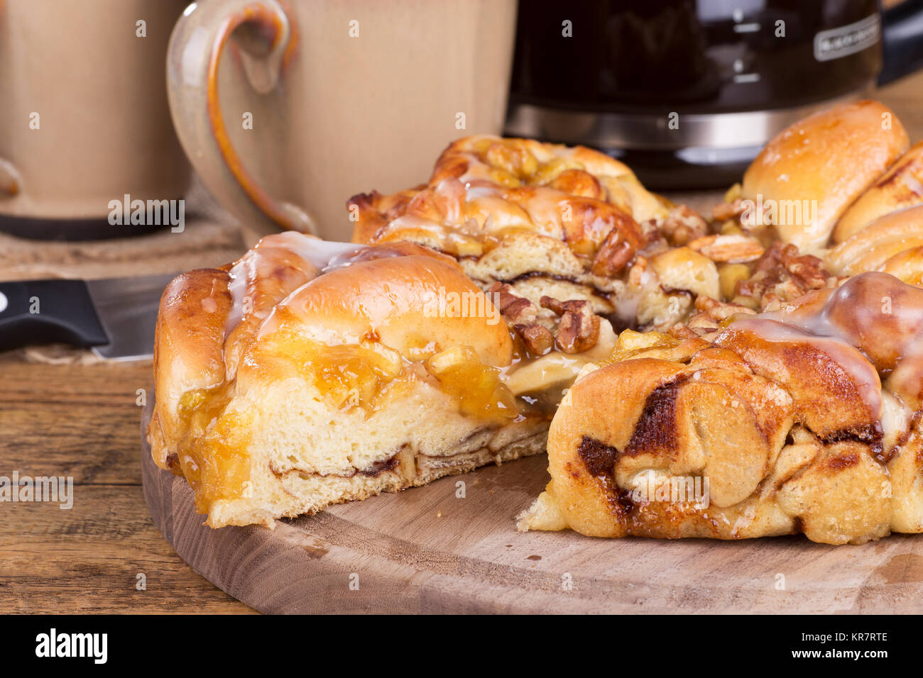 Closeup of a slice of apple pecan sweet bread on a wooden platter Stock Photo