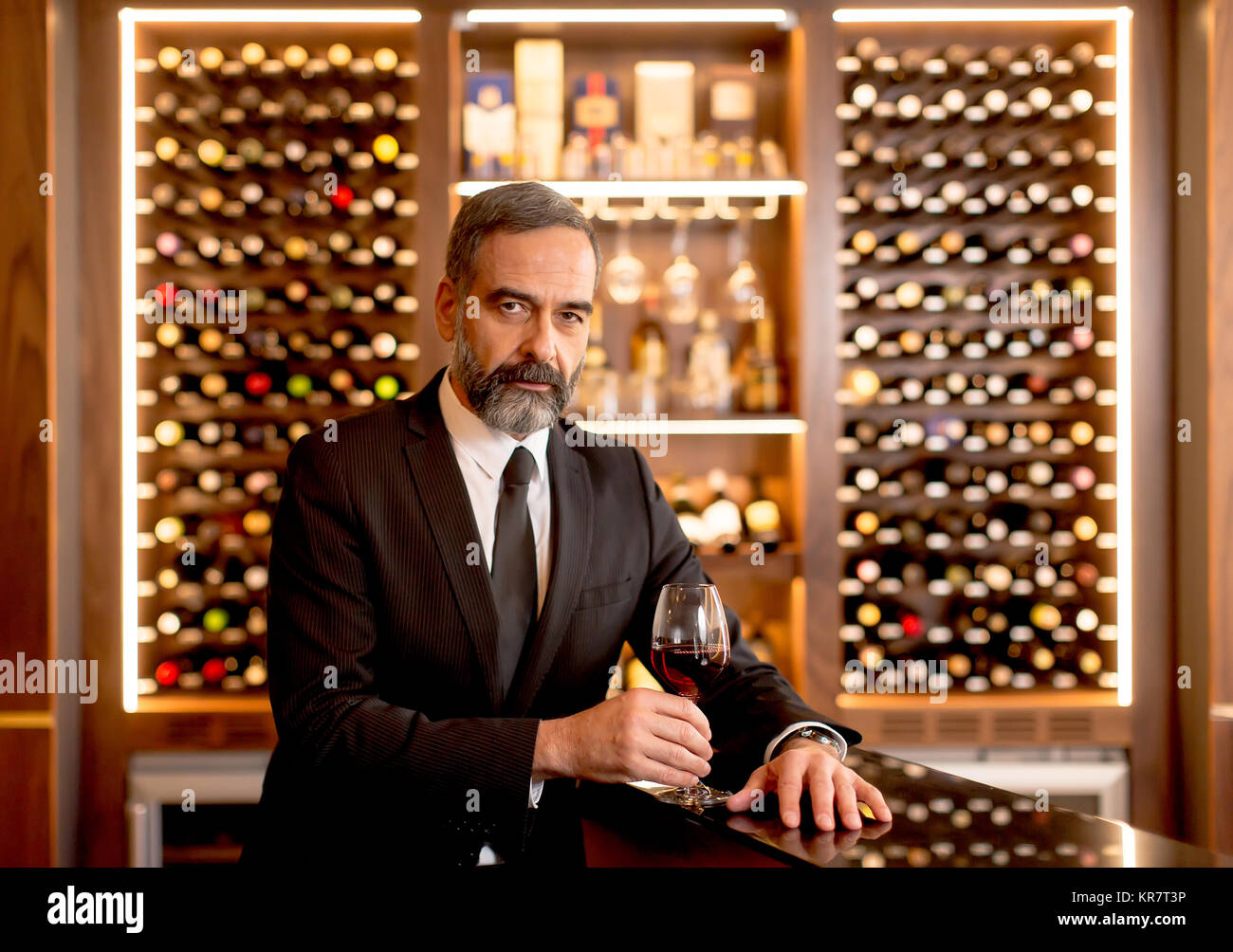 Handsome mature man tasting glass of red wine Stock Photo - Alamy