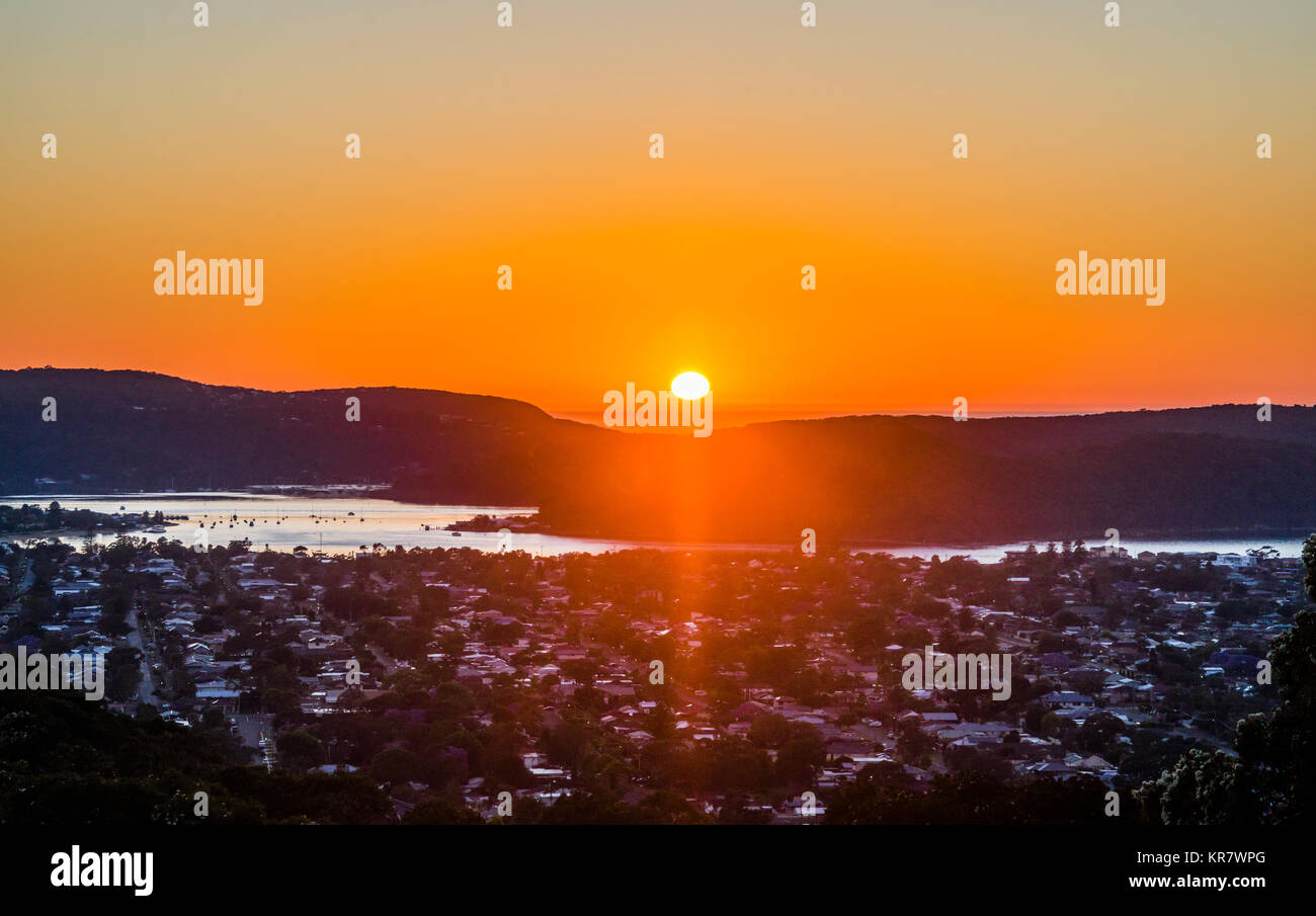 Australia, New South Wales, Central Coast, Umina and Ettalong, Brisbane Water, sun rising over Killcare on the Bouddi Peninsula Stock Photo