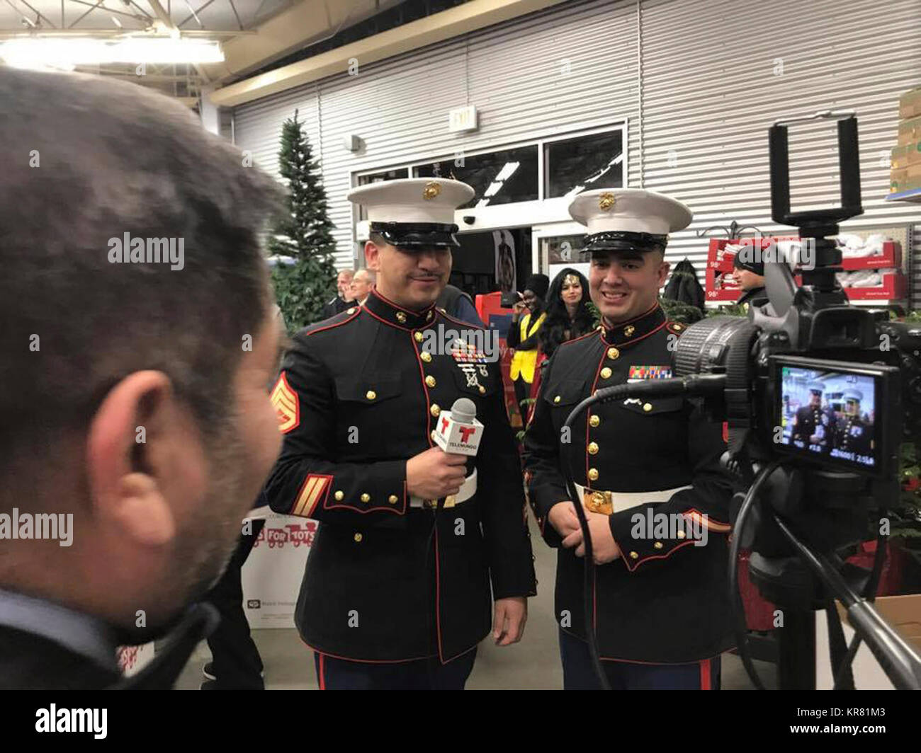 U.S. Marine Corps Staff Sgt. Mario Roman, Staff Non Commissioned Officer at Recruiting Sub-station Sandy, and Staff Sgt. Robert Dohse, Salt Lake City Toys for Tots coordinator at Marine Corps Reserve Company F, conduct and interview with a local television station at the 17th Annual Toy Shop in Salt Lake City, Utah, Dec. 5, 2017.  The mission of the U. S. Marine Corps Reserve Toys for Tots Program is to collect new, unwrapped toys during October, November and December each year, and distribute those toys as Christmas gifts to less fortunate children in the community in which the campaign is co Stock Photo