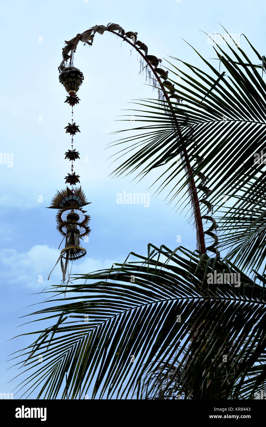 Traditional Bali Penjor. Bamboo pole with decoration on village street. Indonesian art and culture. Stock Photo
