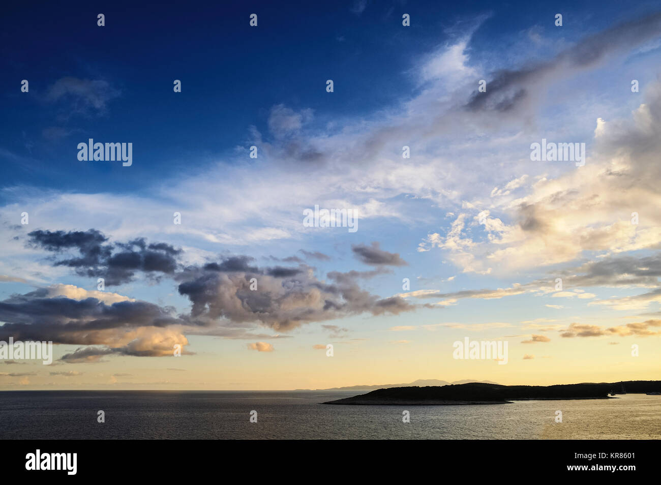 evening sky with great clouds over the sea and an island Stock Photo