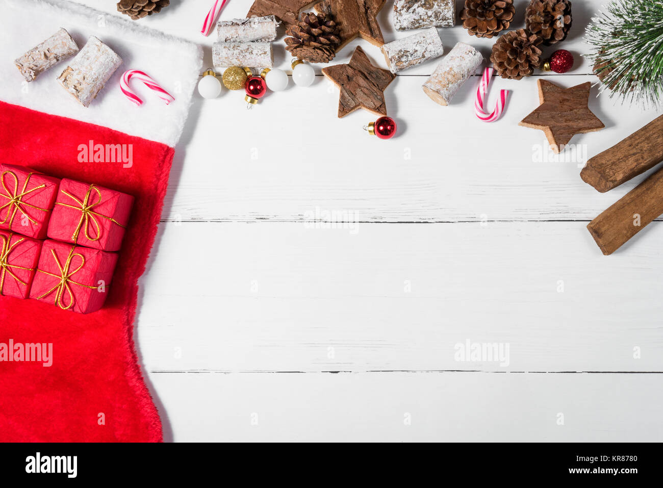 Christmas Stocking and Ornaments Spread Out over White Wooden Table Stock Photo