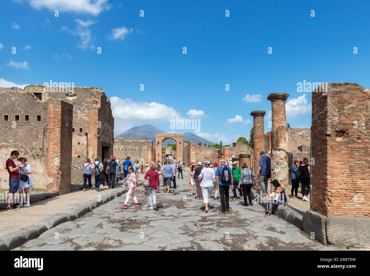 Tourists in the ruins of the Roman Forum at Pompeii ( Pompei ) with Mount Vesuvius in the background, Naples, Campania,Italy Stock Photo