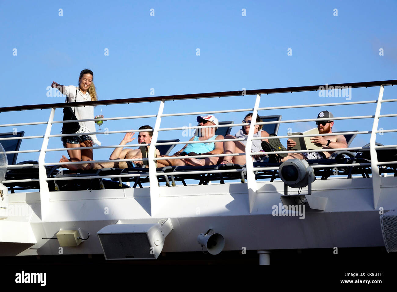 Passengers on the Liberty of the Seas relax on lawn chairs on deck 12 and catch a few rays of sunshine. Stock Photo