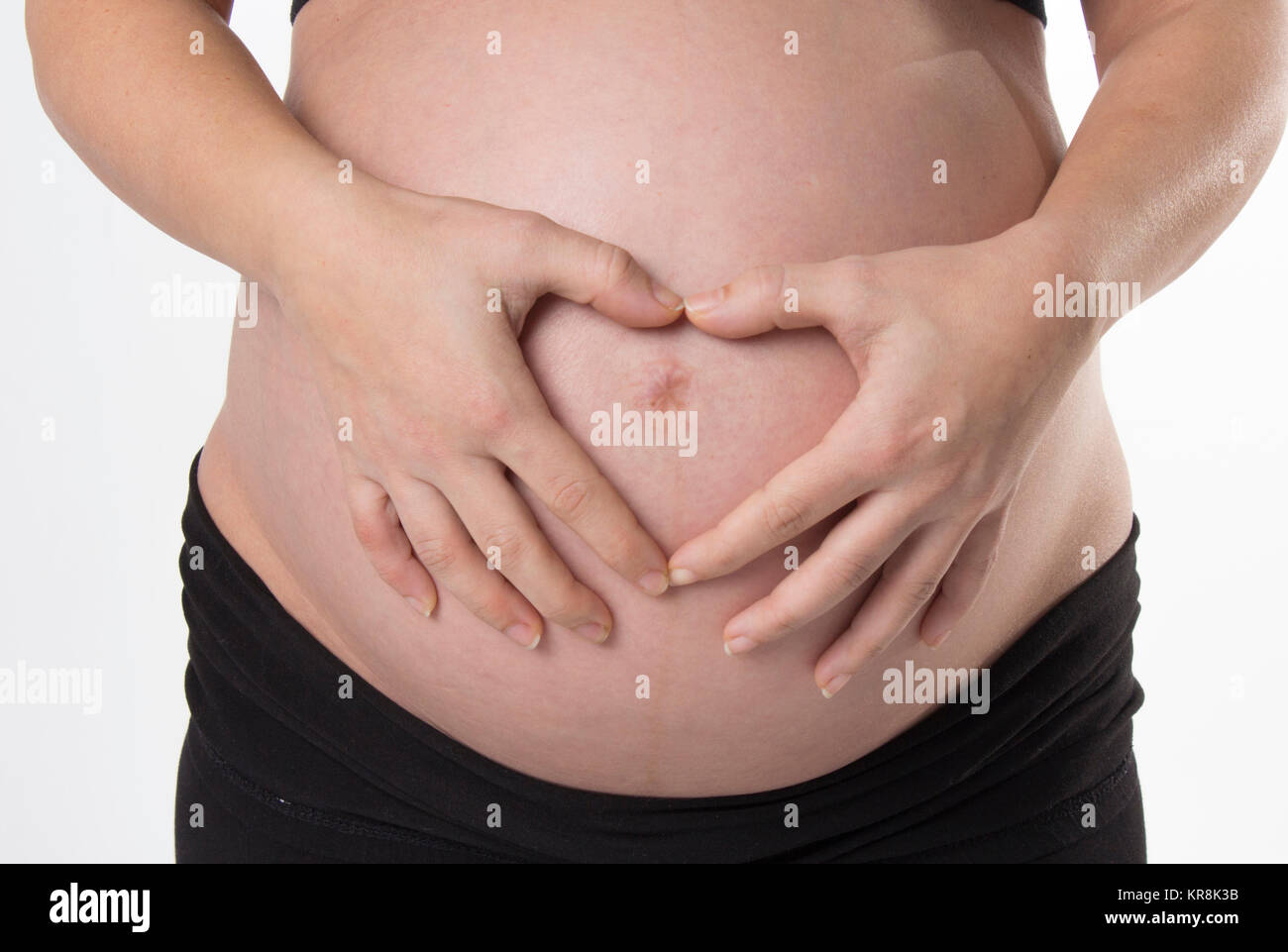 Pregnant Woman holding her hands on beautiful belly Stock Photo - Alamy