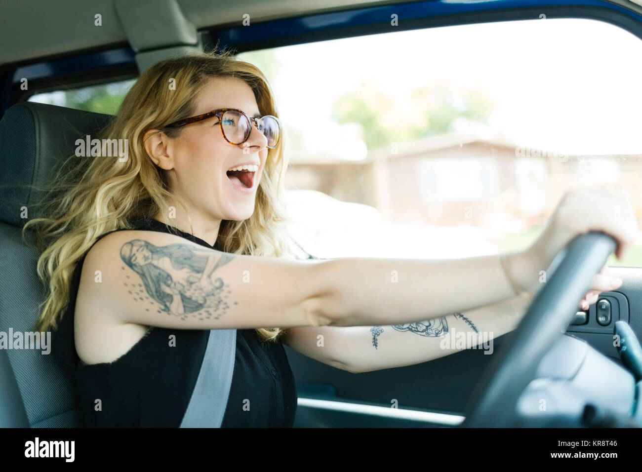 Woman driving car and laughing Stock Photo Alamy