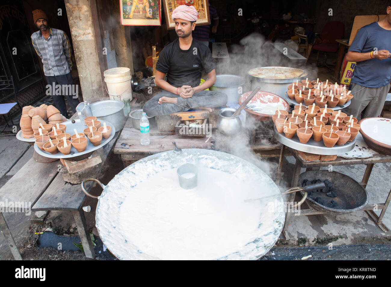 A vendor selling pots of mishti doi (sweet curd) at a food hotel in Allahabad, India Stock Photo