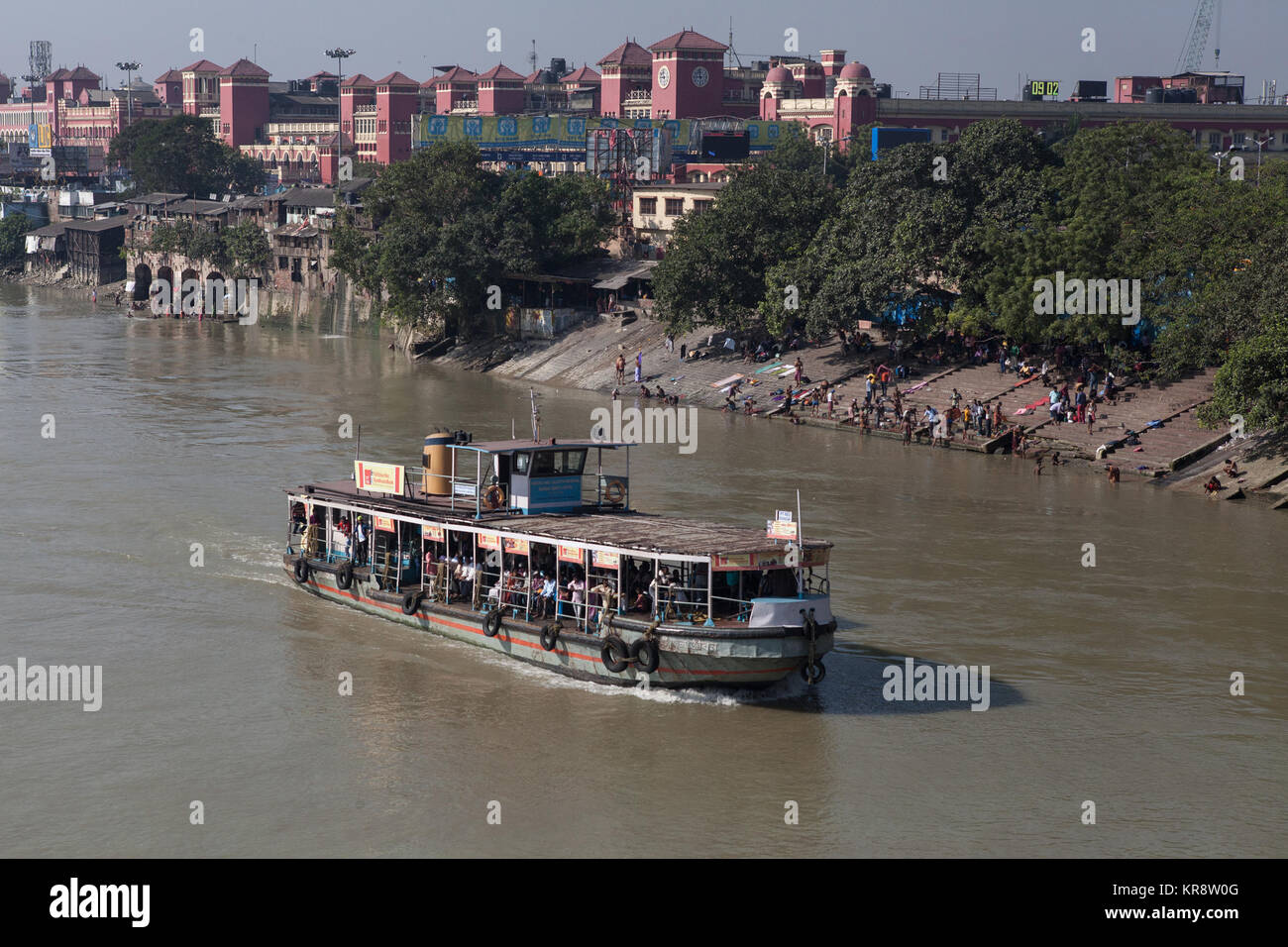 Passenger steam ferry on the Hooghly River with Howrah Railway Station in the background, Kolkata, India Stock Photo