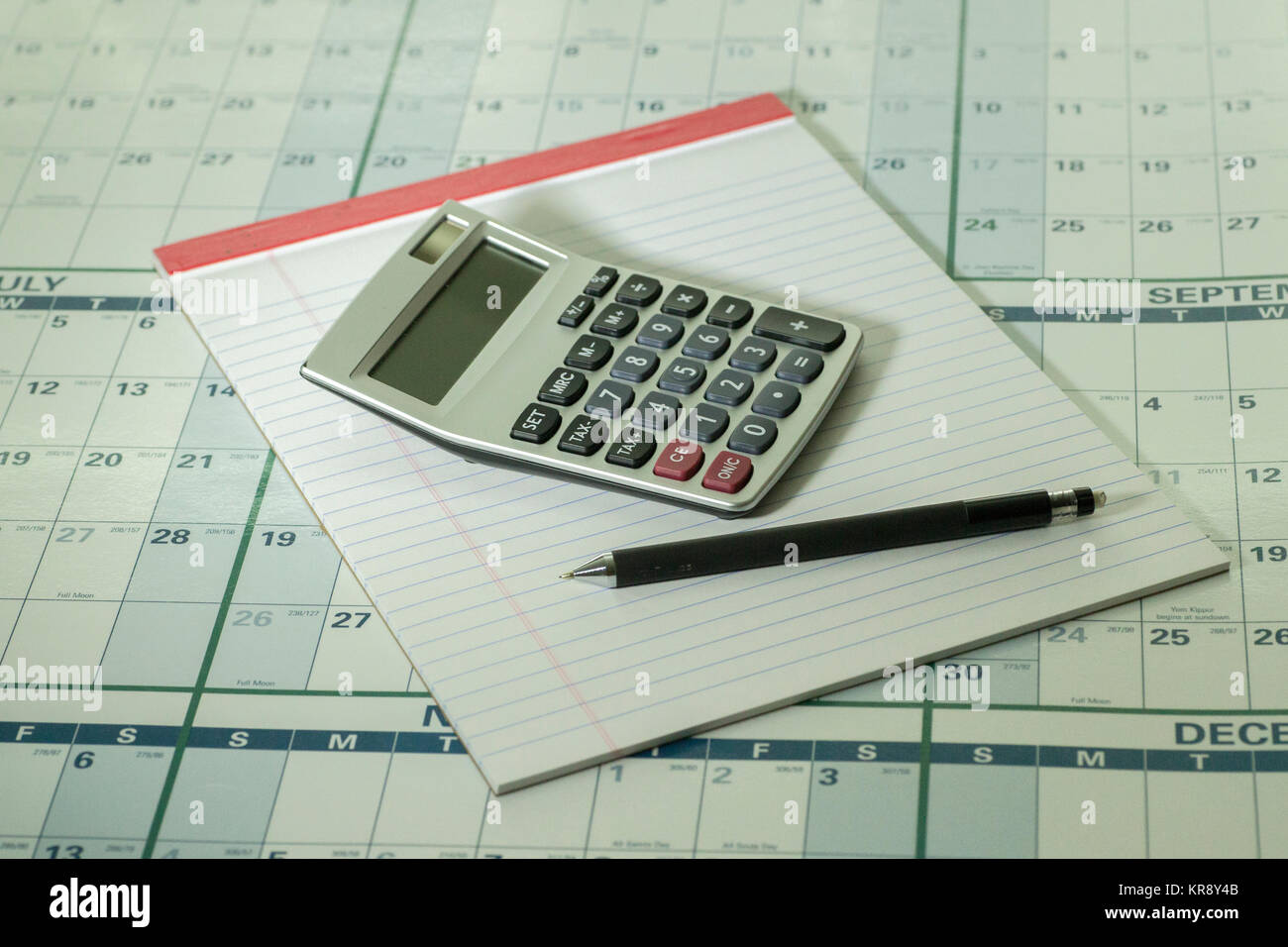 Calculator pad and pencil on calandar background Stock Photo Alamy