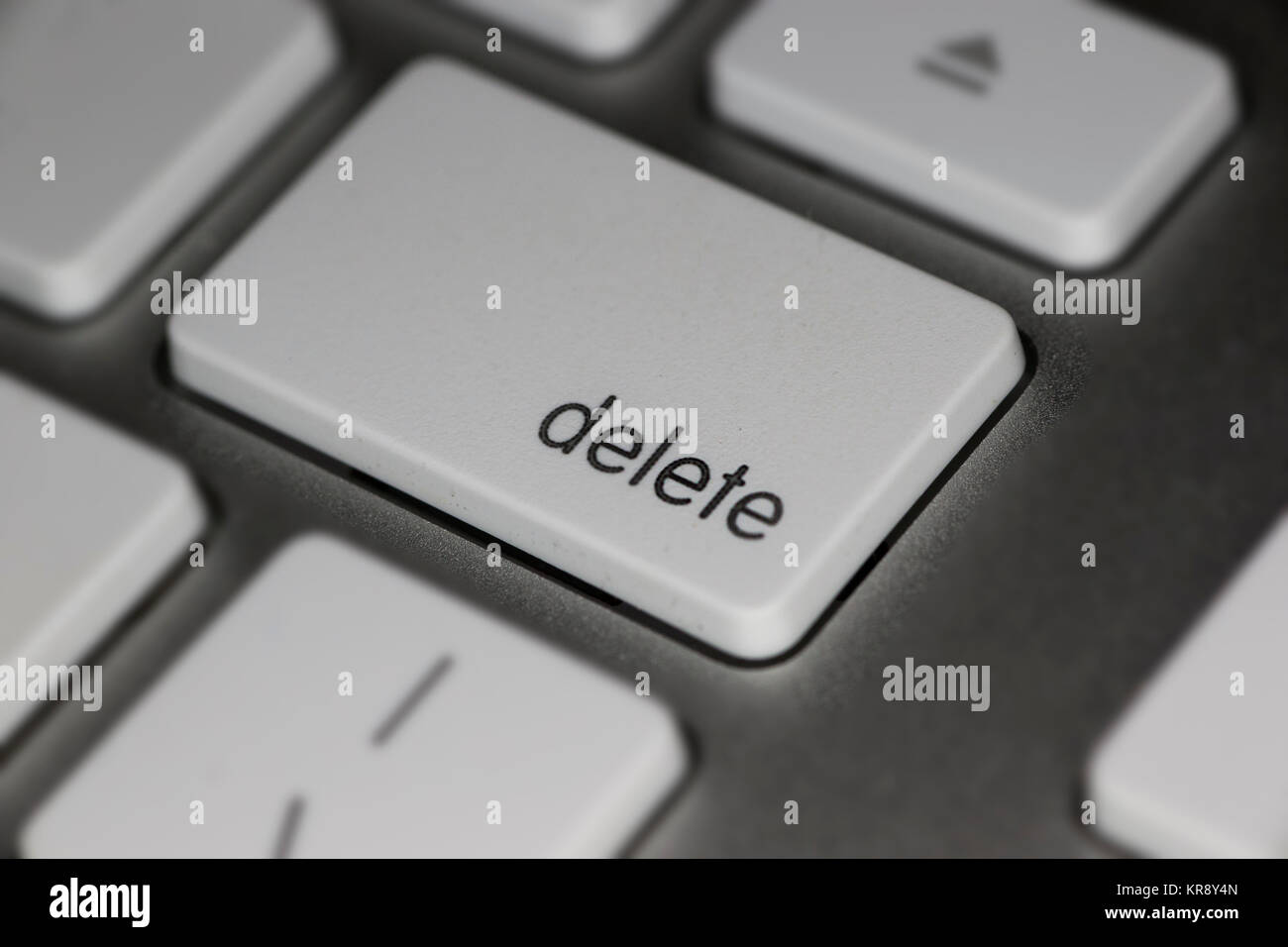Closeup of delete key on computer keyboard with white keys on dark background Stock Photo