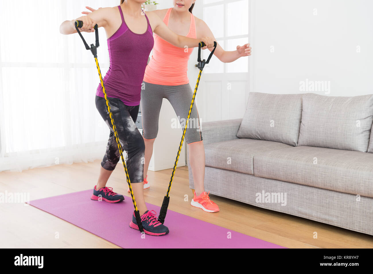 powerful attractive female fitness girl using resistance band training body with her workout teacher at home Stock Photo Alamy