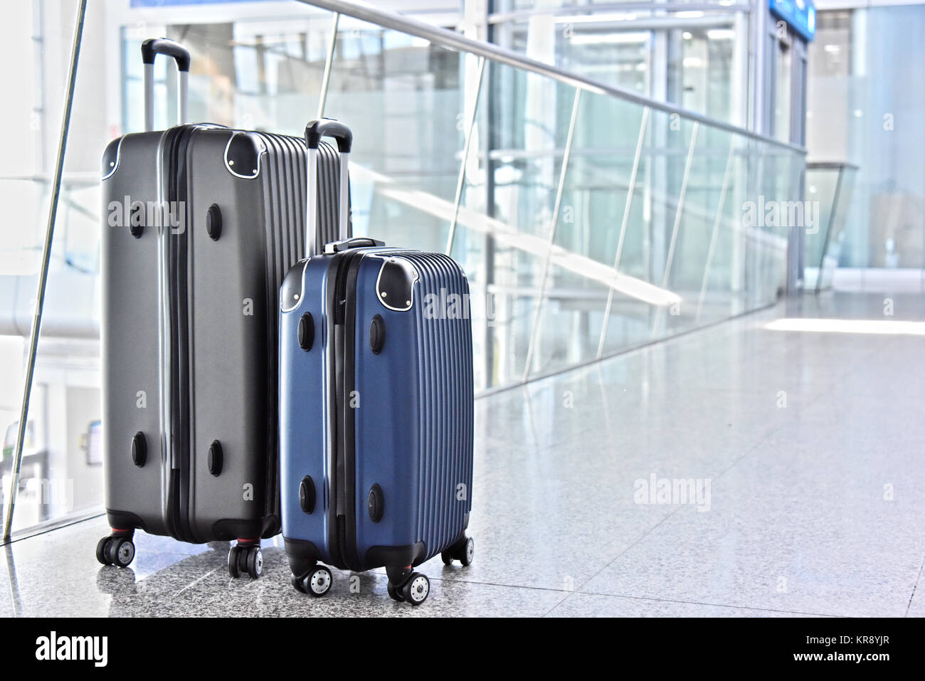 Two plastic travel suitcases in the airport hall Stock Photo Alamy