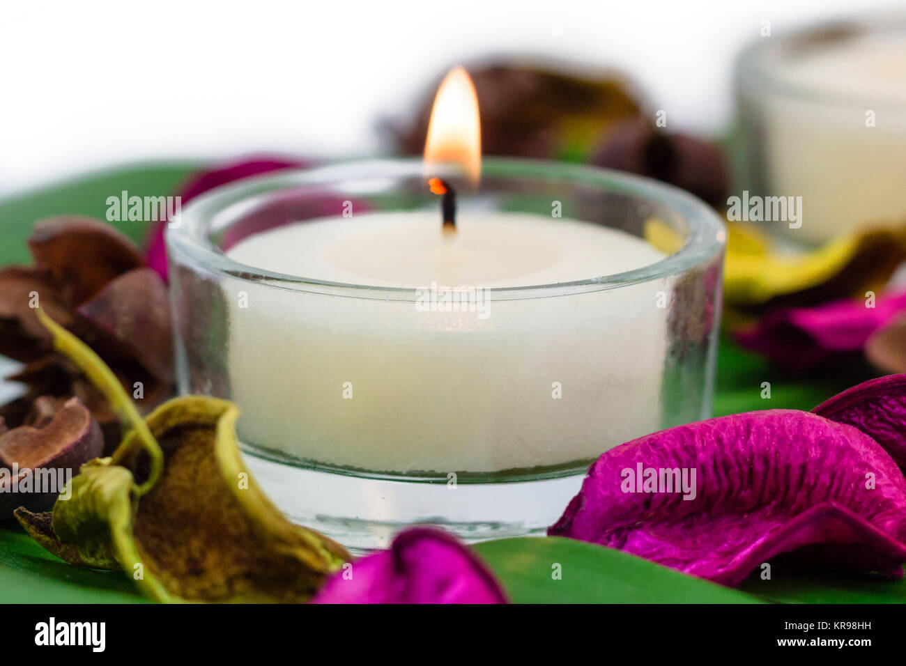 Composition of burning candles fragrant potpourri on monstera leaf Stock Photo