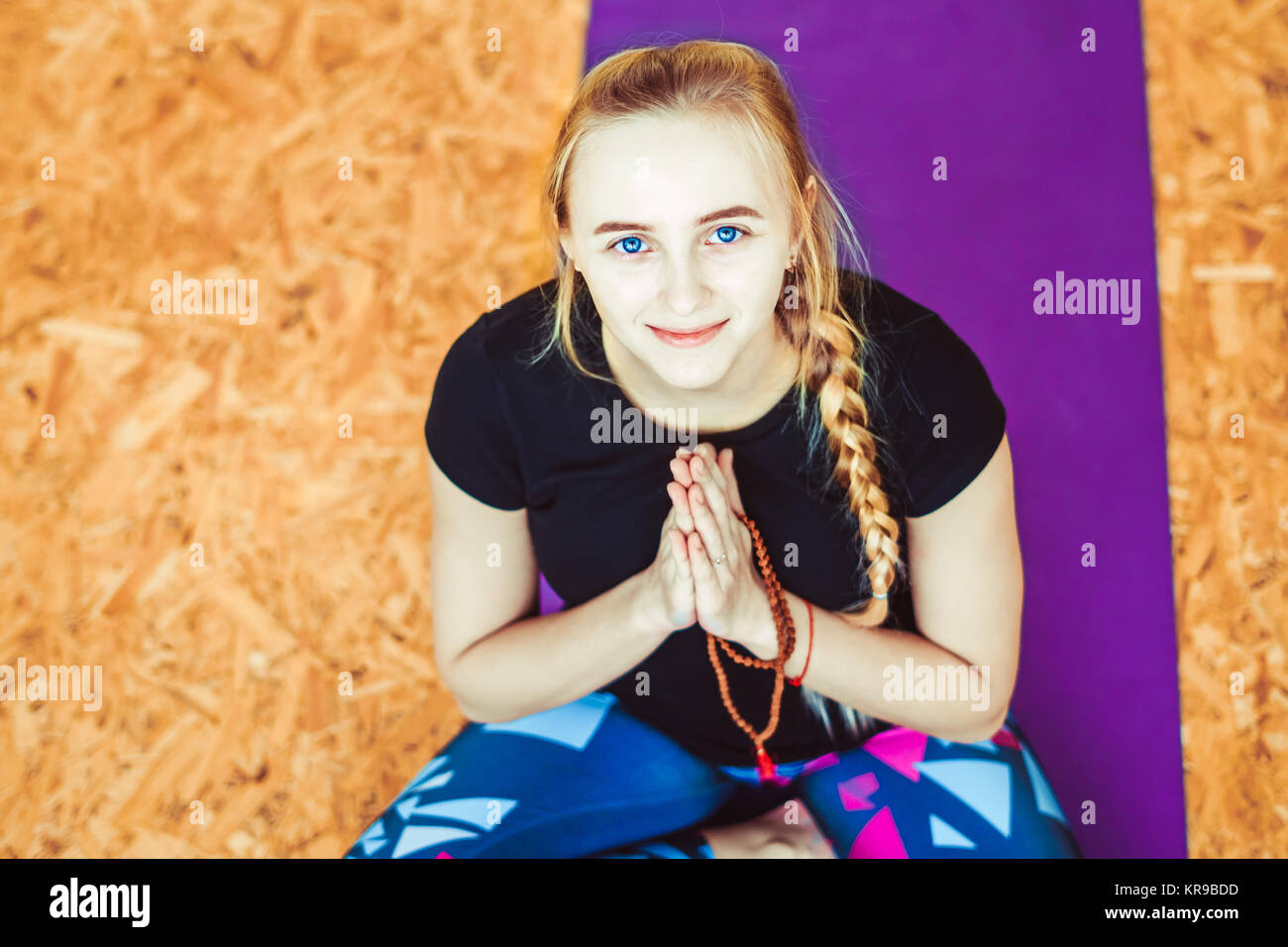 young blonde woman sitting in Lotus position in the yoga room Stock ...
