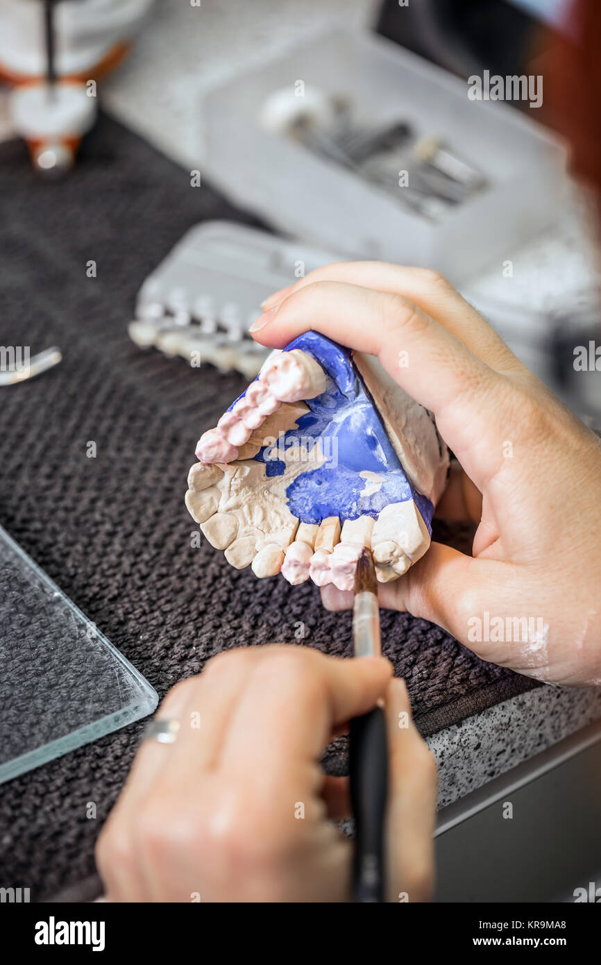 Dental technician applying ceramics Stock Photo Alamy