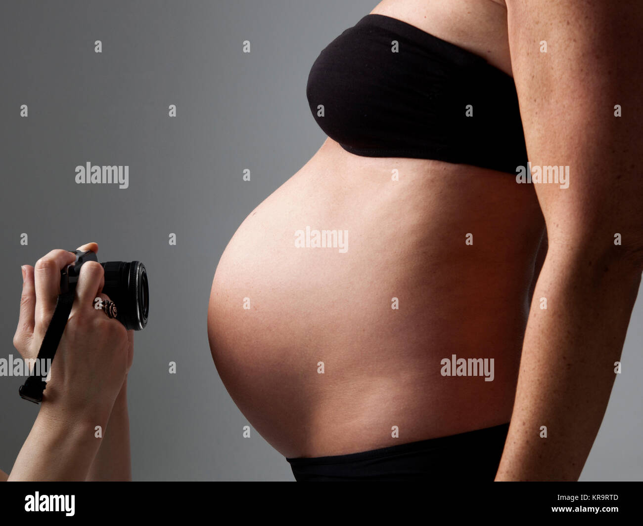 belly of a pregnant woman being photographed Stock Photo