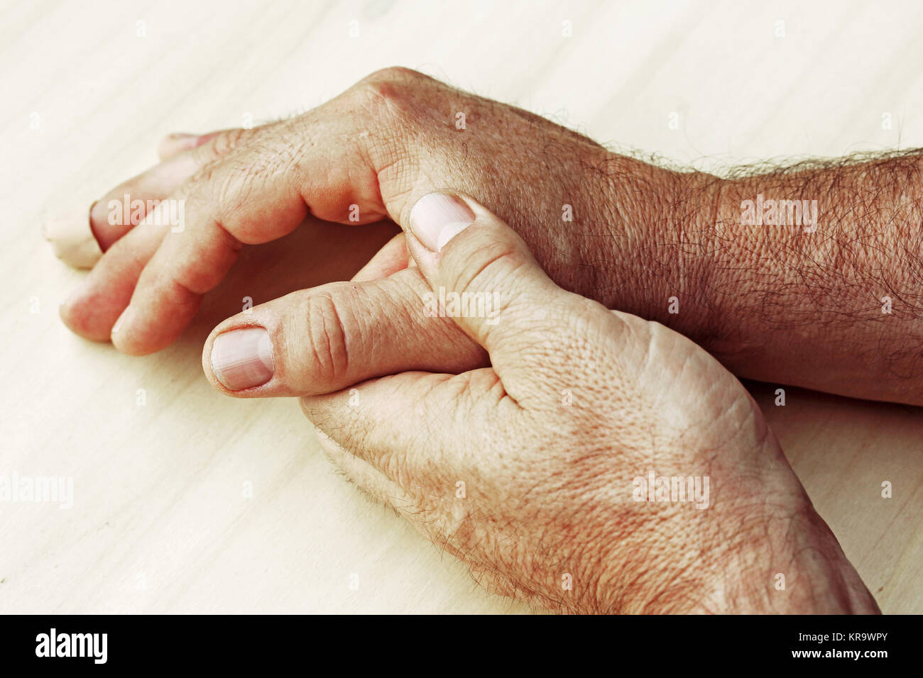 an elderly man has pain in his hands Stock Photo