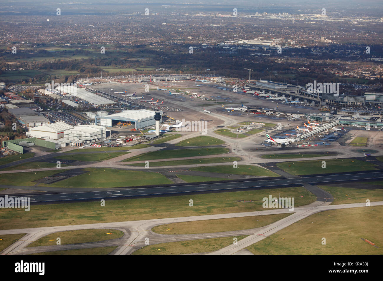 An aerial view showing hangars, the control tower, aprons and terminals of Manchester Airport. Stock Photo