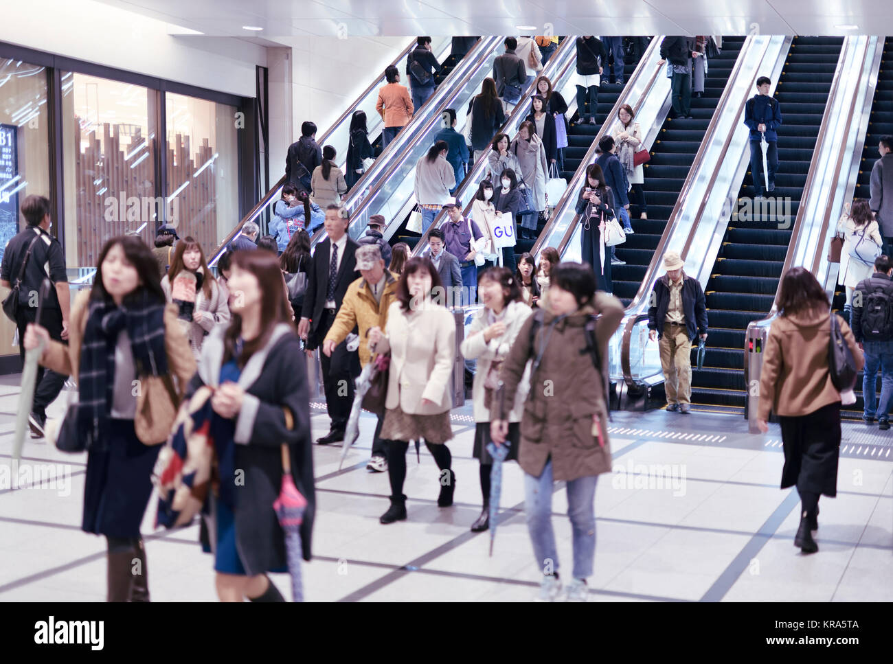 People on train station escalators in Osaka, Japan Stock Photo