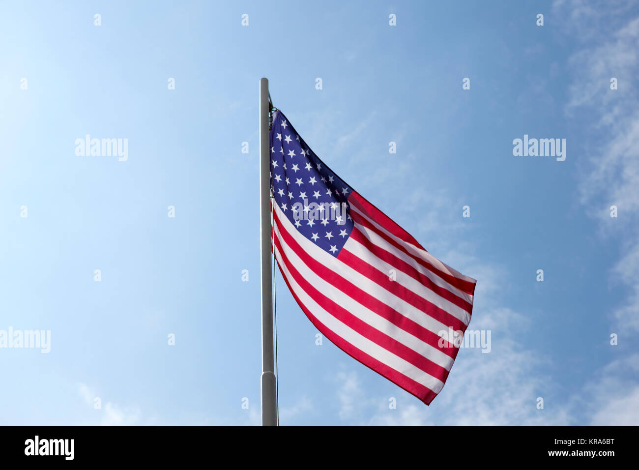 Flag of United States on a flagpole in front of blue sky Stock Photo ...