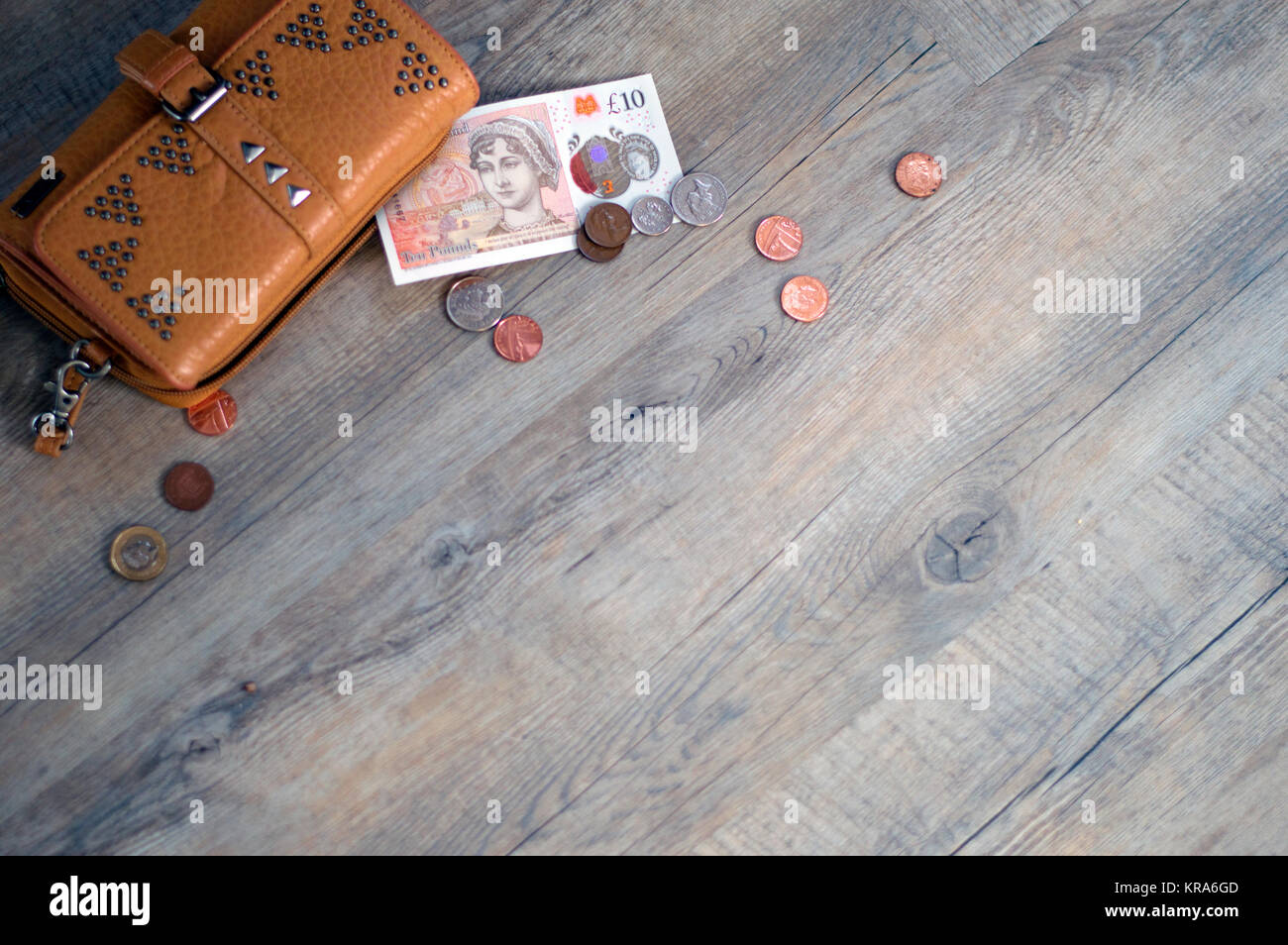 Money (loose change) and wallet on oak plank background. Stock Photo