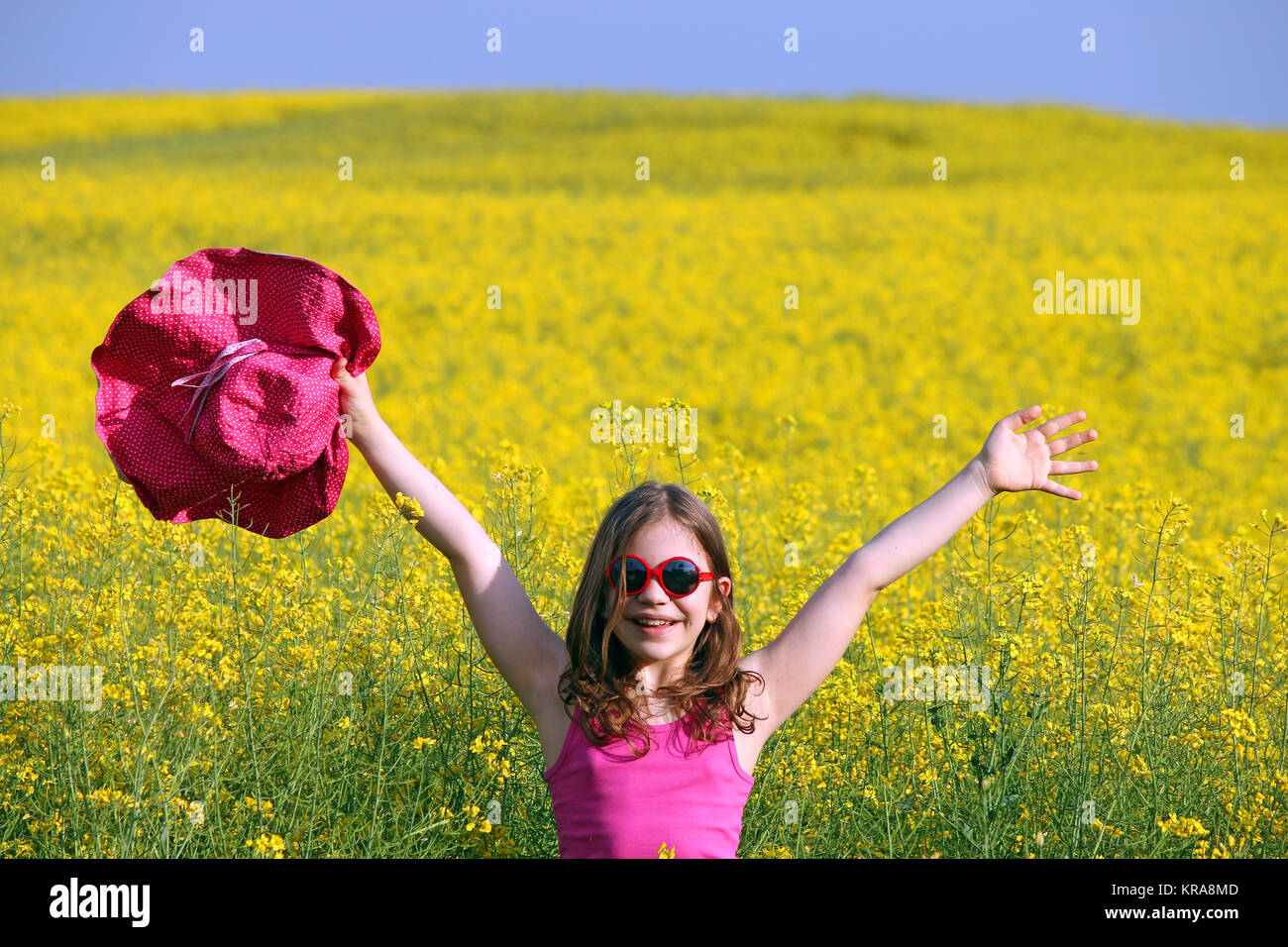 Happy little girl on field spring season Stock Photo - Alamy
